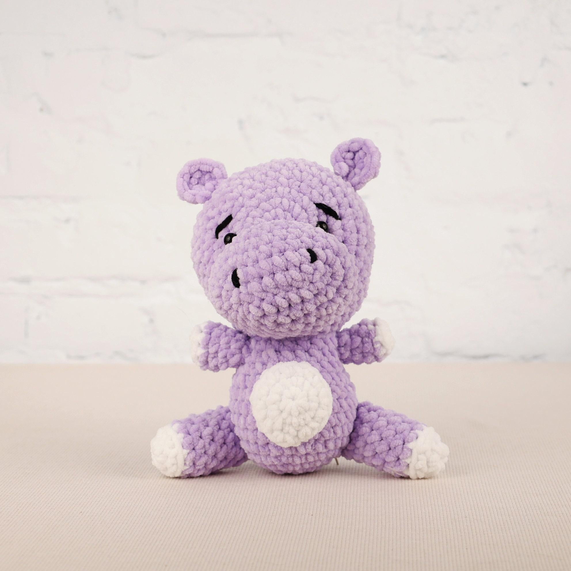 a purple crocheted stuffed animal sitting on a table